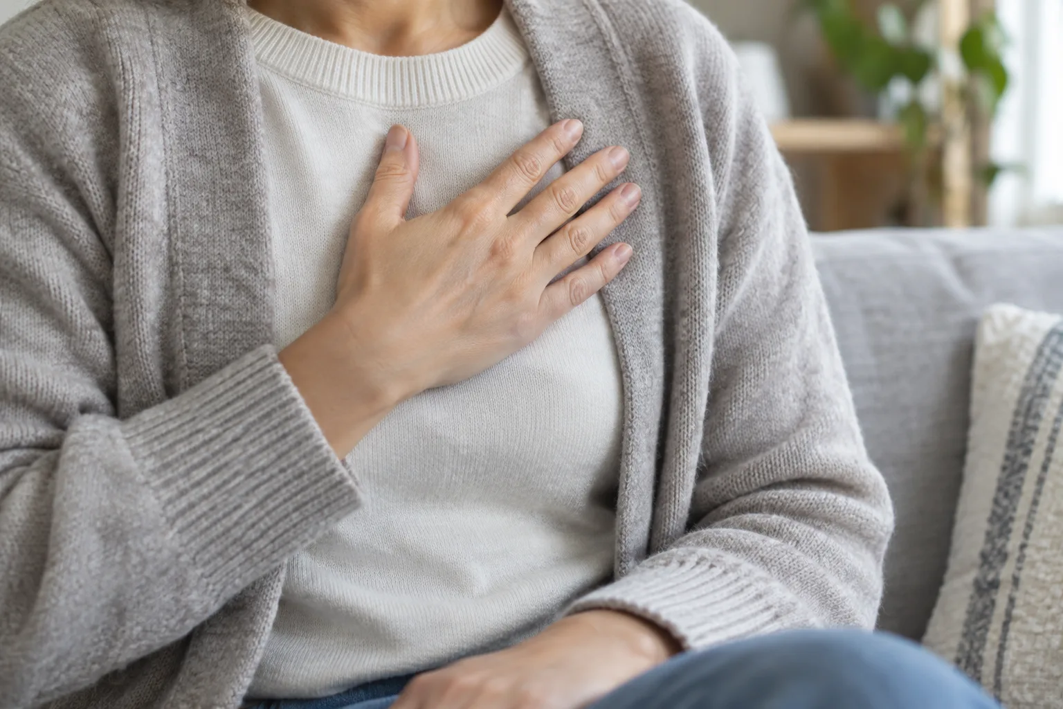 Une personne pose une main sur sa poitrine, attentive à son rythme cardiaque.